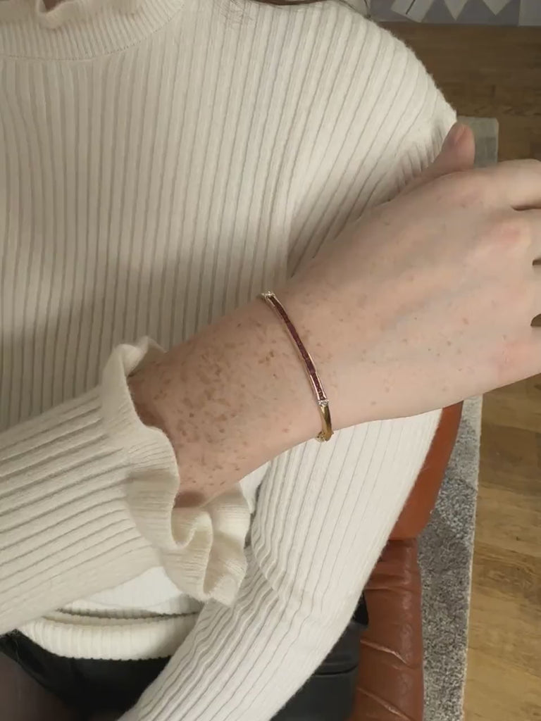 Bangle opening with calibrated rubies and diamonds on yellow gold